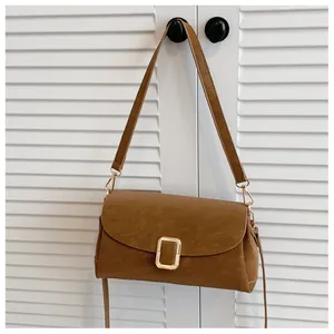 Detailed macro view of the matte brown vintage shoulder bag with golden metal buckle