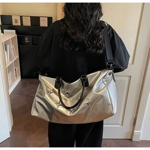 Détail d'un sac argenté avec étoiles métalliques et bandoulière noire sur modèle