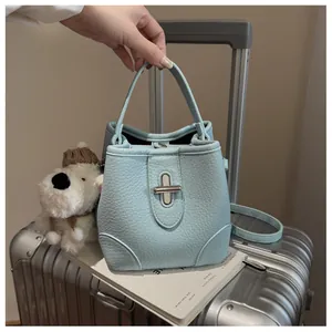 Detail of light blue bucket bag showing premium lychee grain leather and silver lock