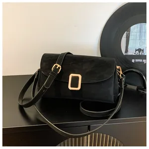Detail of black suede rectangular crossbody bag with elegant gold hardware buckle