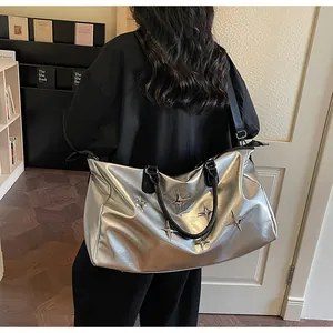 Vue arrière d'un sac cabas argenté avec clous étoiles porté en bandoulière par un mannequin