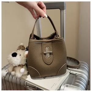 Detailed close-up of brown pebble leather bucket bag with silver metal swivel lock