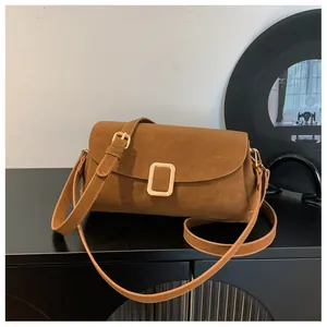 Detail of caramel suede square bag with golden square buckle and adjustable strap