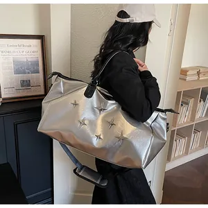 Sac fourre-tout argenté avec étoiles chromées et bandoulière noire sur mannequin