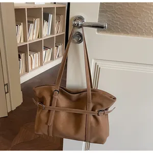 Nahaufnahme der braunen Vintage-Einkaufstasche mit Metallschnalle an einem Türgriff