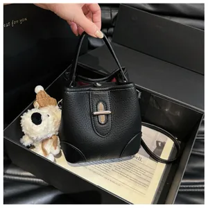 Detail of black lychee grain leather bucket bag with silver twist lock in a gift box