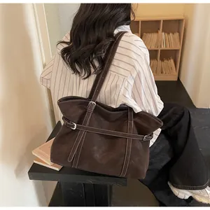 Nahaufnahme einer großen dunkelbraunen Tote-Bag mit weißen Kontrastnähten und Schnalle
