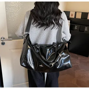 Détail du grand sac cabas noir laqué avec rivets étoiles argentés et bandoulière large