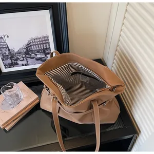 Detail der braunen Ledershopper mit gestreiftem Innenfutter und sicherem Reißverschluss
