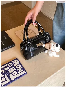 Nahaufnahme einer schwarzen glänzenden Bowlingtasche mit silbernen Details und Anhänger
