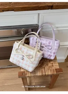 Detail of pink and purple plaid tote bags featuring cute bow ties and heart charms