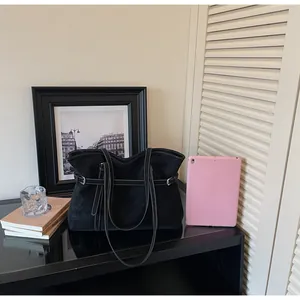 Minimalistische schwarze Shopper-Tasche aus Wildlederimitat mit Metallschnalle im Wohndesign