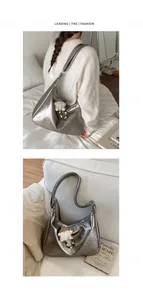 Detail of silver metallic hobo bag with pleated texture and plush charm pendant