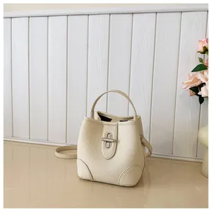 Detailed view of the pebble grain leather texture on a beige bucket handbag