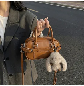 Detail view of brown vintage PU leather bowling bag with cute plush rabbit charm
