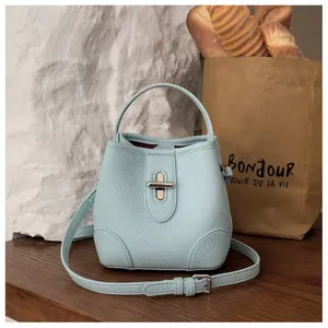 Close-up of light blue bucket bag with lychee texture and silver metal buckle