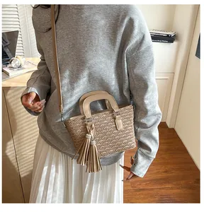 Detail of beige pleated bucket bag with tassel charm and detachable shoulder strap