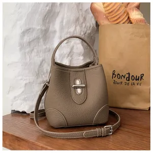 Detail of lychee pattern leather bucket bag with metallic twist lock and handle