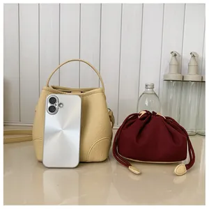 Mini beige bucket bag with burgundy drawstring pouch and smartphone for size reference