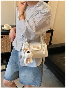 Detail der weißen Bowling-Tasche mit Herz-Deko und Plüsch-Welpenanhänger aus Leder