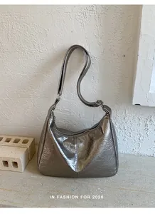 Detail shot of pleated metallic silver hobo bag showing texture and adjustable strap