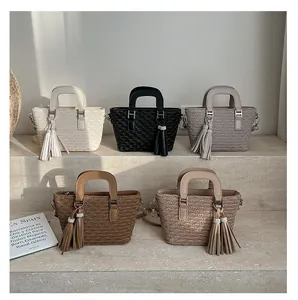 Five assorted woven texture bucket bags with tassels on elegant stone steps