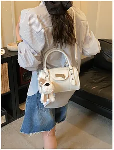 Weiße Boston-Tasche mit Litschimuster am Modell mit süßem Plüsch-Hundeanhänger