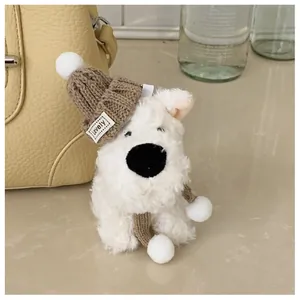Close-up of cute plush dog charm with knitted hat and scarf hanging on a yellow bucket bag