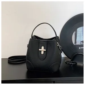 Detailed shot of black lychee grain leather bucket bag with silver cross-turn lock