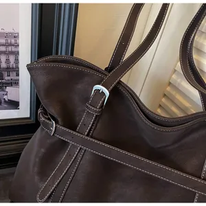 Detail der dunkelbraunen Totebag mit Kontrastnähten und silberner Metallschnalle