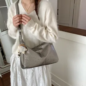 Silver metallic crinkled tote bag with plush charm shown on female model in white