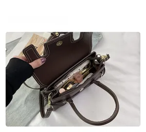 Vue intérieure du sac à main en similicuir marron avec coutures blanches et rangement