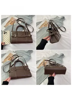 Détails de ce sac bandoulière marron foncé en cuir avec surpiqûres blanches et boucle dorée