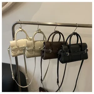 Détail de sacs à bandoulière en cuir minimalistes en quatre couleurs sur un support