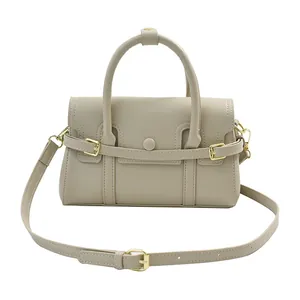 Détail du sac à main beige rectangulaire avec boucle dorée et bandoulière amovible