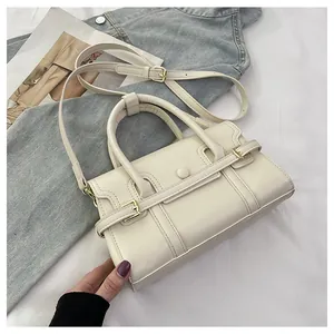 Détail de sac à main crème avec poignées rondes et bandoulière réglable vue de dessus