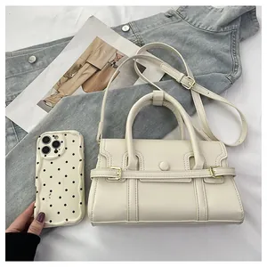 Sac à main crème chic avec surpiqûres ondulées et coque à pois sur fond en jean bleu