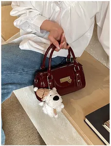Detail der burgunderroten glänzenden Bowlingtasche mit Schloss und Plüschanhänger