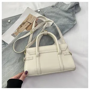 Vue détaillée du sac à main en cuir crème avec double poignées et ferrures dorées