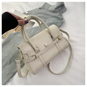 Détail d'un sac à main en similicuir crème avec poignées et une fine bandoulière réglable