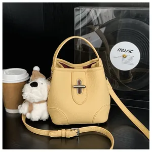 Detail of yellow lychee grain leather bucket bag featuring silver twist-lock and top handle