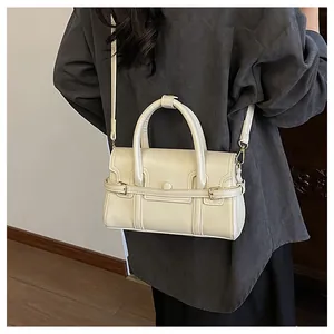 Détail du sac à main blanc crème avec boucle en métal doré et poignée ronde