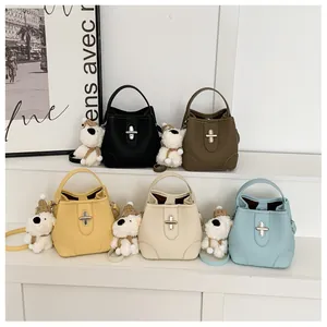 Detail of five-color leather bucket bags with plush puppy charms and silver twist locks