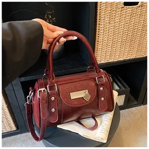 Detailansicht der glänzenden weinroten Boston Bag mit Nieten und Herzanhänger