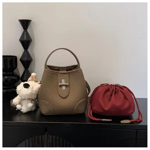 Detail of lychee pattern leather bucket bag with silver twist lock and red drawstring pouch