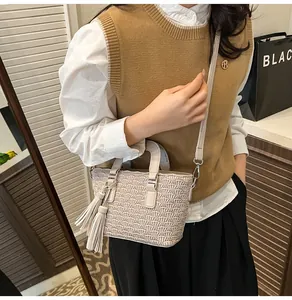 Detail of cream bucket bag featuring quilted fan texture and long side leather tassels