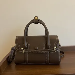 Sac à main rétro en cuir mat marron foncé avec coutures blanches et boucle dorée