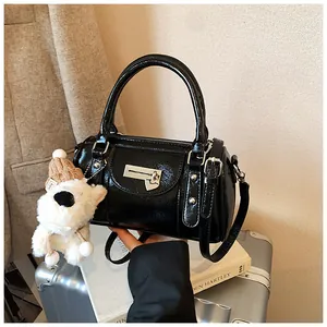 Details der schwarzen glänzenden Bowlingtasche mit silberner Hardware und Plüsch-Anhänger