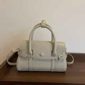 Sac à main chic en cuir synthétique abricot avec détails dorés sur bois sombre