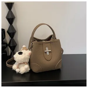Detailed view of brown lychee grain leather bucket bag with silver twist lock buckle